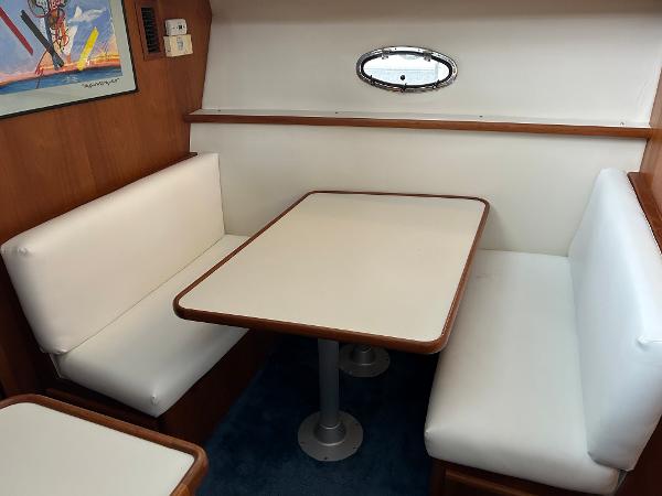 Slide: The Image of 1992 Carver 38 Aft Cabin interior with white cushioned seating and wooden table. - 23