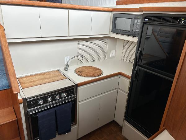 Slide: The Image of 1992 Carver 38 Aft Cabin kitchen with stove, microwave, and refrigerator. - 24