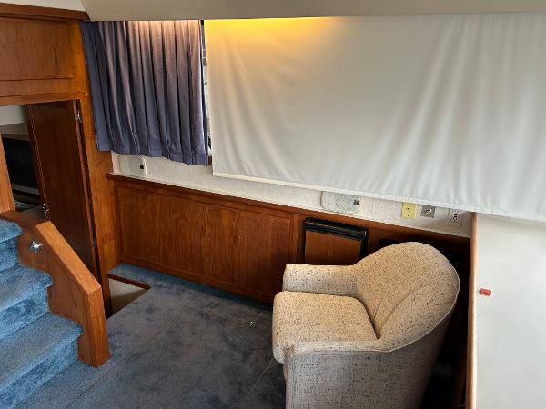 Slide: The Image of 1992 Carver 38 Aft Cabin interior with chair, blue carpet, and wood paneling. - 25