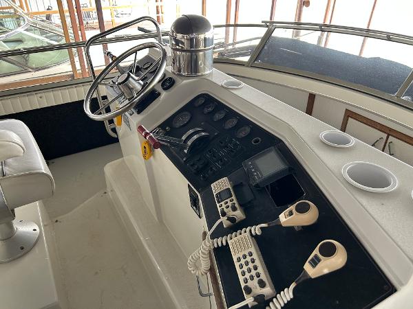 Slide: The Image of 1992 Carver 38 Aft Cabin helm with steering wheel, controls, and communication devices. - 28