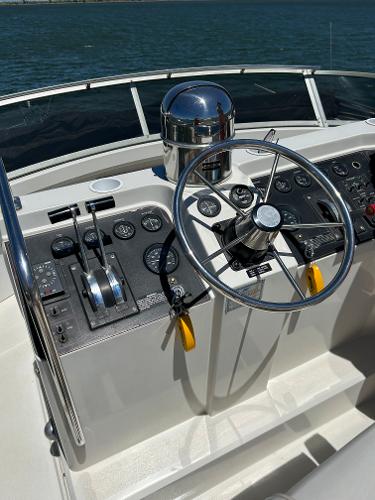 Slide: The Image of 1992 Carver 38 Aft Cabin helm with steering wheel and controls, overlooking water. - 31
