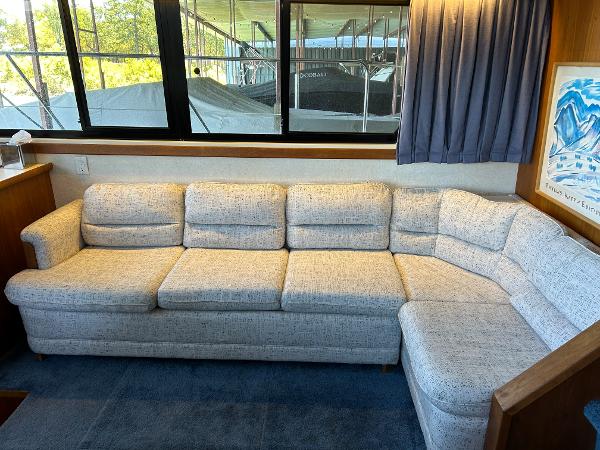 Slide: The Image of 1992 Carver 38 Aft Cabin interior with a cozy L-shaped sofa and large windows. - 34