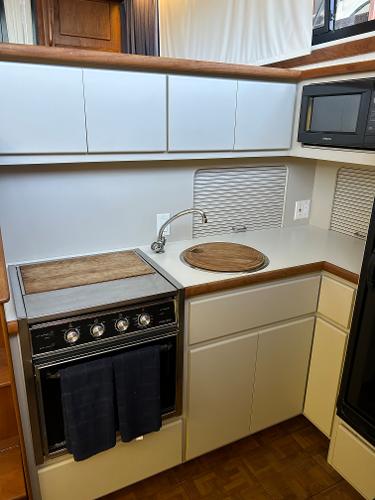 Slide: The Image of 1992 Carver 38 Aft Cabin kitchen with stove, sink, and microwave. - 38