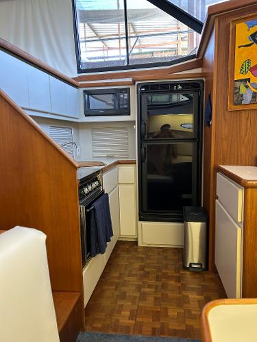 Slide: The Image of Interior of 1992 Carver 38 Aft Cabin yacht kitchen with wood accents and appliances. - 39