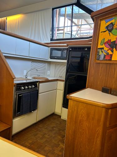 Slide: The Image of 1992 Carver 38 Aft Cabin kitchen with wood cabinetry, stove, and microwave. - 40