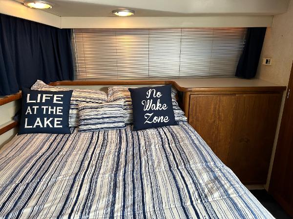 Slide: The Image of 1992 Carver 38 Aft Cabin bedroom with striped bedding and nautical-themed pillows. - 46