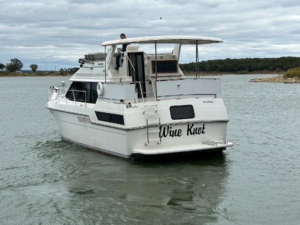 Slide: The Image of 1992 Carver 38 Aft Cabin boat named "Wine Knot" cruising on a calm lake. - 9