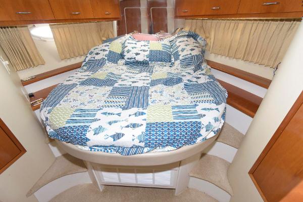 Slide: The Image of 2006 Carver 38 Super Sport boat interior bedroom with quilted bed and wooden cabinets - 17