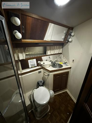 Slide: The Image of 1988 Carver 4207 Aft Cabin bathroom with wood accents and compact design. - 20