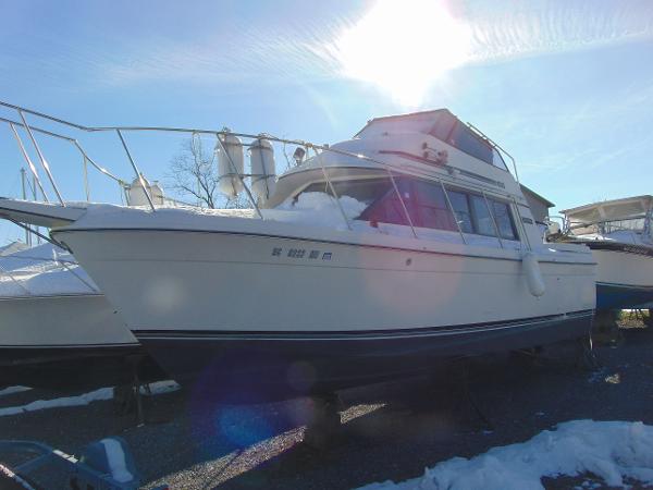 Slide: The Image of 1987 Carver Mariner 28 boat in snowy outdoor setting, sun shining above. - 1