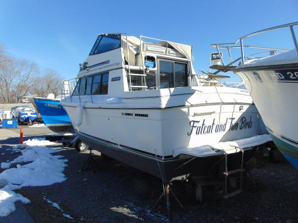 Slide: The Image of 1987 Carver Mariner 28 boat on land, partially covered in snow. - 2