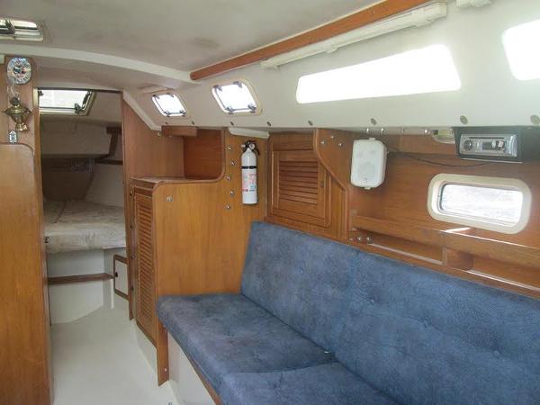 Slide: The Image of 1999 Catalina 30 MkIII sailboat interior with blue seating and wooden cabinetry - 5