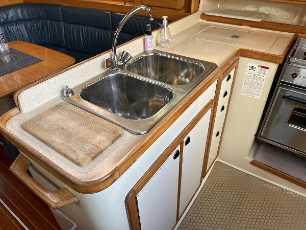 Slide: The Image of Galley kitchen in 2000 Catalina 34 MkII sailboat with double sink and wooden accents. - 11