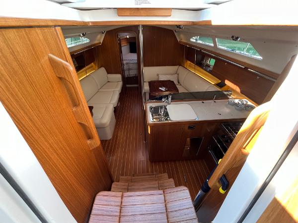 Slide: The Image of 2024 Catalina 355 yacht interior with wooden finish, kitchen, and seating area. - 15