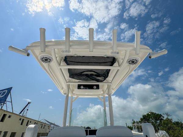 Slide: The Image of 2023 Caymas 26 HB boat with T-top and rod holders under a sunny sky. - 16