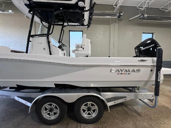 Slide: The Image of 2024 Caymas 26 Hybrid boat on a dual-axle trailer in a showroom. - 1
