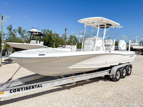 Slide: The Image of 2024 Caymas 26 HB boat on a Continental trailer, parked outdoors under a clear blue sky. - 1