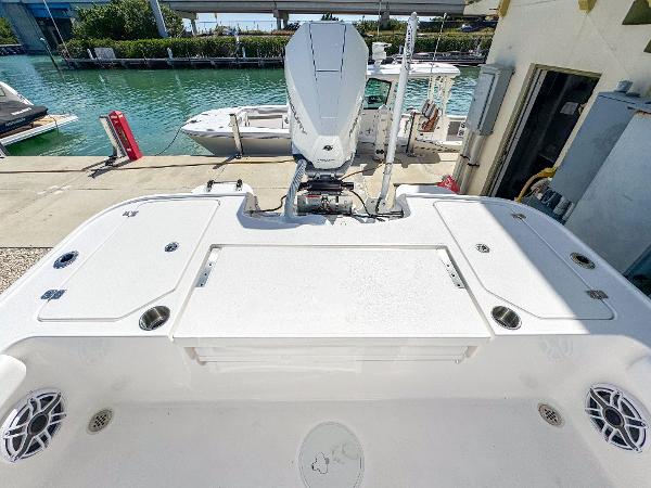 Slide: The Image of 2024 Caymas 26 HB boat with outboard motor, docked by a waterfront. - 10
