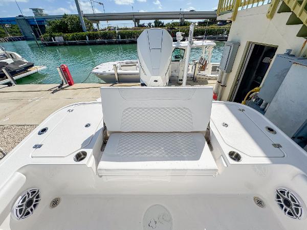 Slide: The Image of 2024 Caymas 26 HB boat with spacious seating and modern design at a marina. - 11