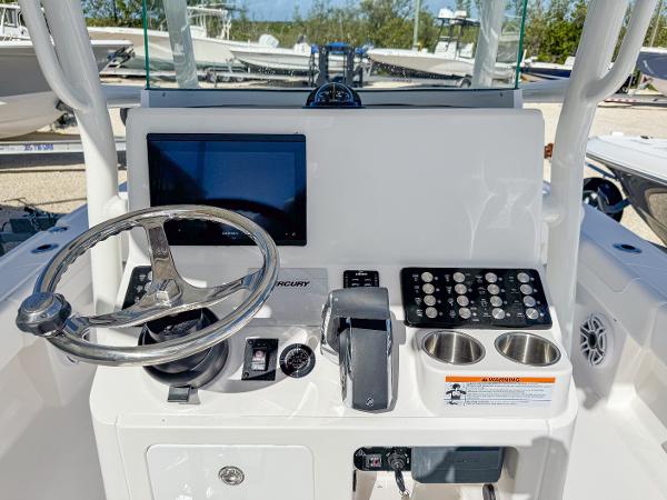 Slide: The Image of 2024 Caymas 26 HB boat dashboard with steering wheel, touchscreen, and control panel. - 12