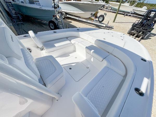 Slide: The Image of 2024 Caymas 26 HB boat with spacious seating and sleek design in a marina setting. - 16