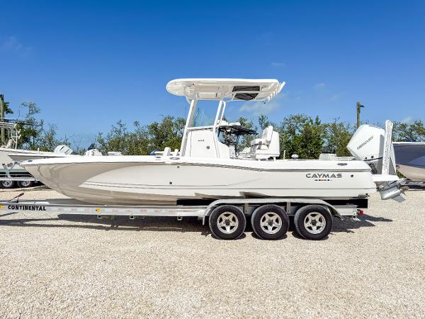 Slide: The Image of 2024 Caymas 26 HB boat on a trailer, parked outdoors under clear blue sky. - 2