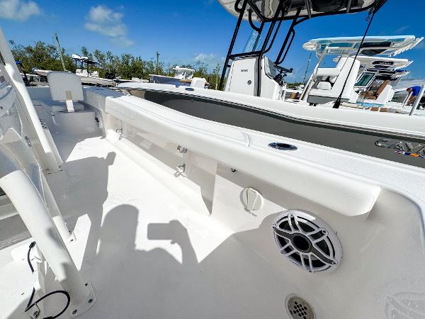 Slide: The Image of 2024 Caymas 26 HB boat interior with white seating and speaker, under clear blue sky. - 24