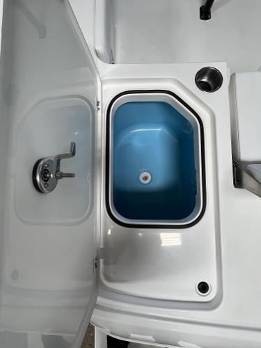 Slide: The Image of 2024 Caymas 26 Hybrid boat livewell with open lid and blue interior. - 26