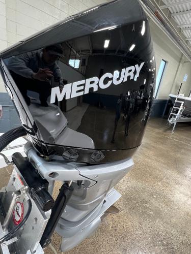 Slide: The Image of 2024 Caymas 26 Hybrid with Mercury outboard motor in showroom. - 29