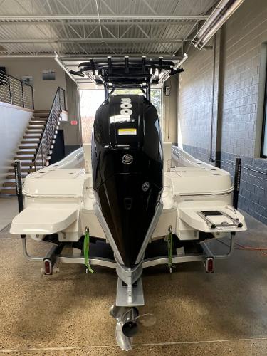 Slide: The Image of 2024 Caymas 26 Hybrid boat in showroom, rear view with outboard motor. - 31