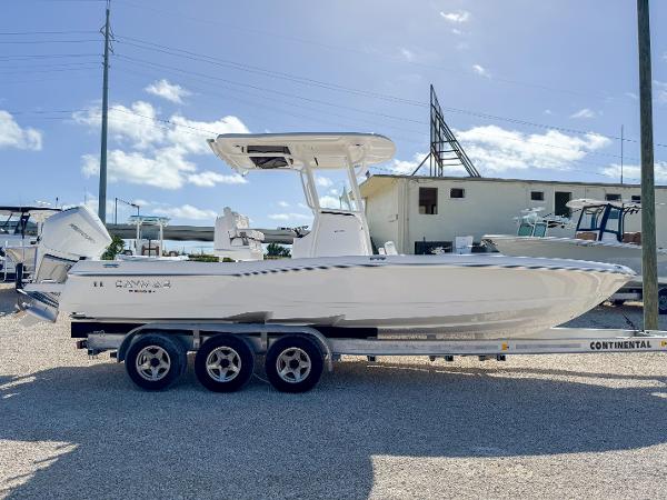Slide: The Image of 2024 Caymas 26 HB boat on a trailer, parked outdoors under a clear sky. - 6