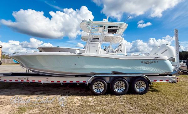 Slide: The Image of 2025 Caymas 281 HB boat on a trailer under a blue sky with clouds. - 1