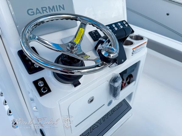Slide: The Image of 2025 Caymas 281 HB boat helm with Garmin navigation system and stainless steel steering wheel. - 22