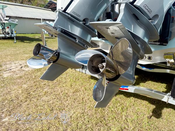 Slide: The Image of 2025 Caymas 281 HB boat propellers on grass, showcasing dual outboard motors. - 30