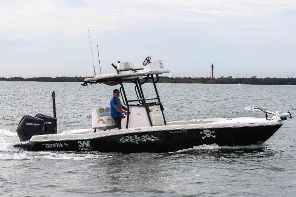 Slide: The Image of 2022 Caymas 281HB Center Console boat cruising on water with lighthouse in background. - 0
