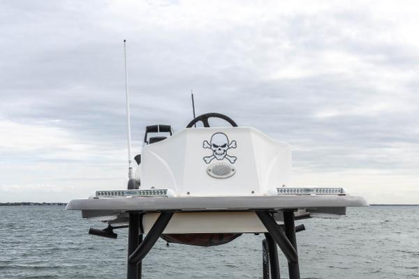 Slide: The Image of 2022 Caymas 281HB Center Console boat with skull and crossbones decal on the water. - 21