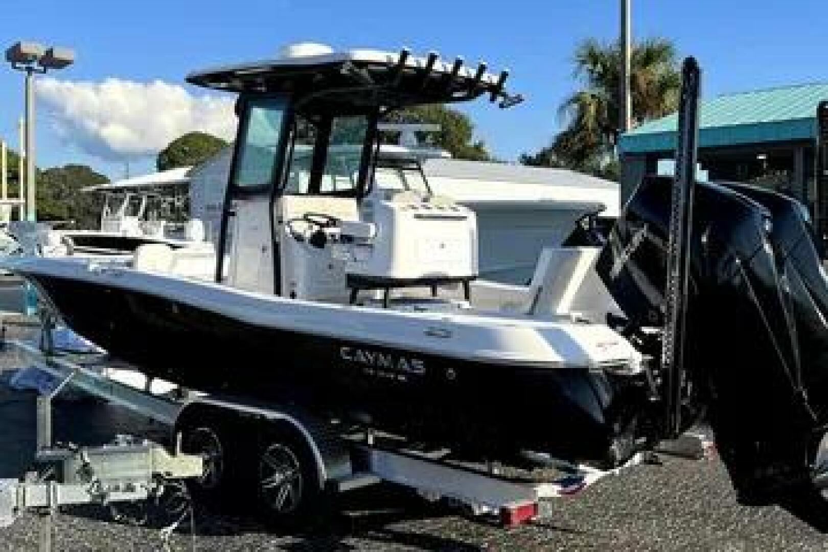 Slide: The Image of 2023 Caymas 28 HB Twin boat on trailer, displayed outdoors. - 5442598