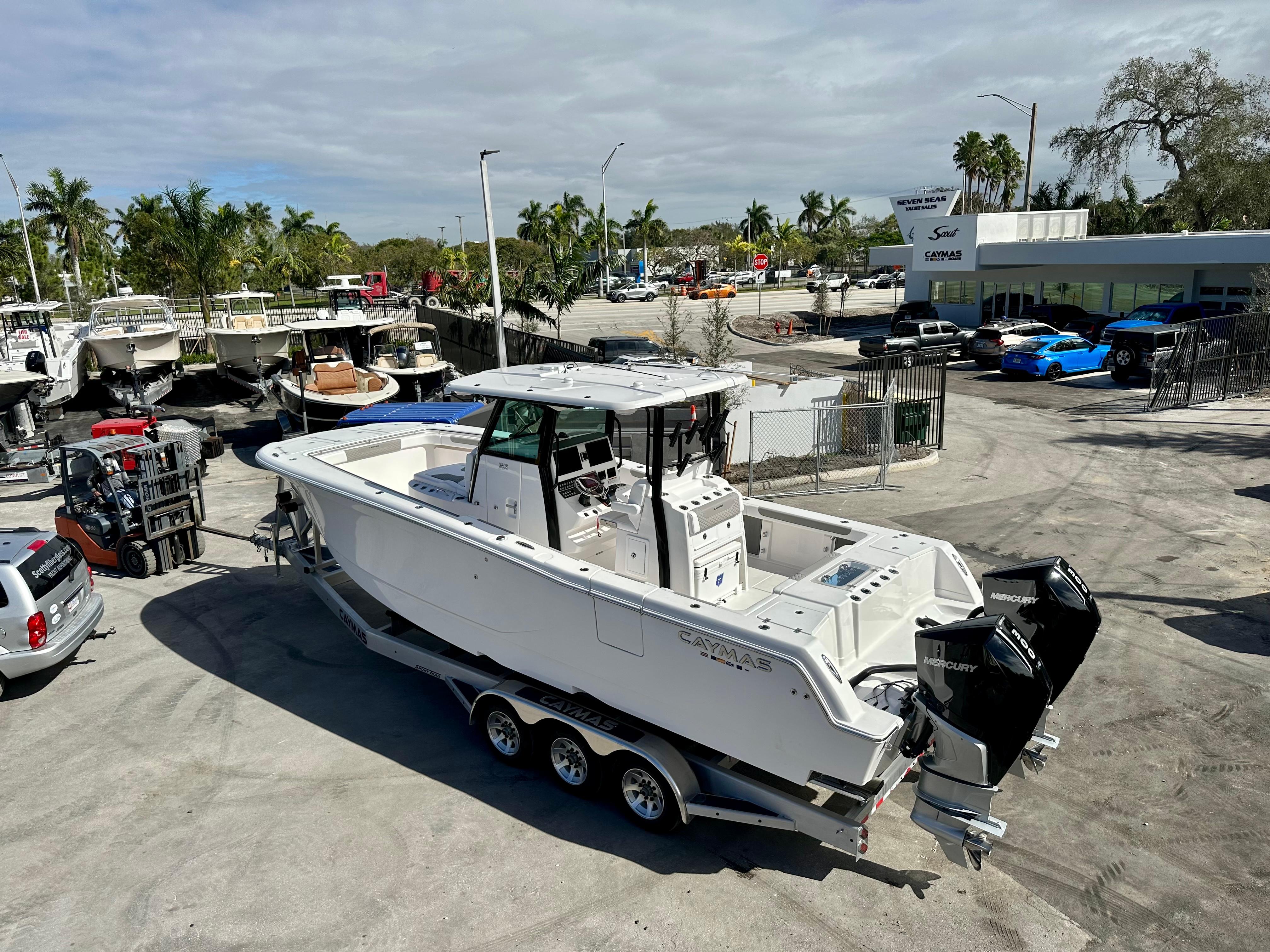 Slide: The Image of 2024 Caymas 30 CT boat on a trailer at a dealership with other boats. - 0