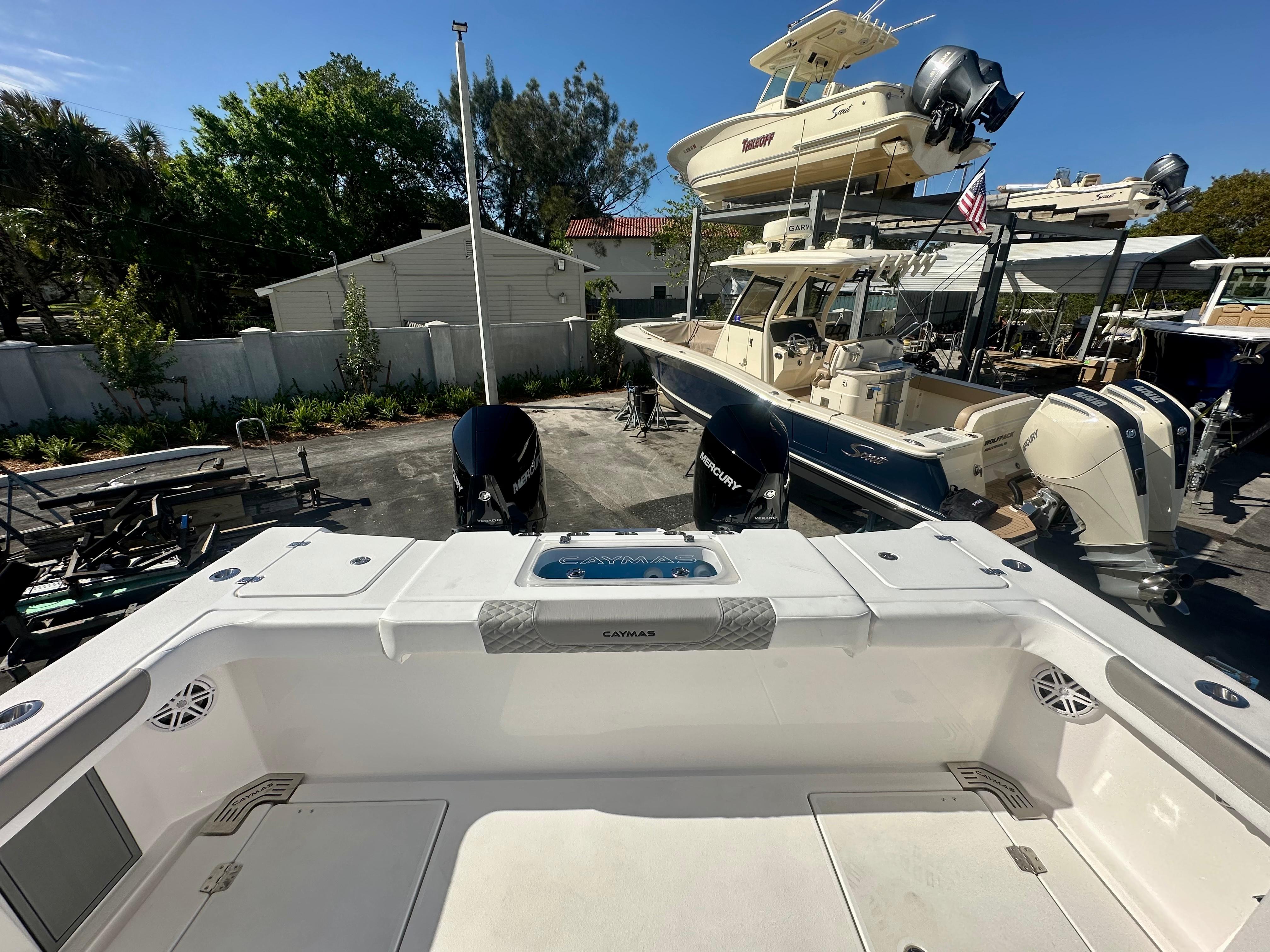 Slide: The Image of 2024 Caymas 30 CT boat with dual Mercury engines in a marina. - 9