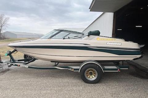 Slide: The Image of 1995 Celebrity 180 Bowrider boat on trailer near a storage building. - 1