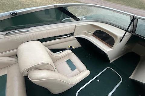 Slide: The Image of 1995 Celebrity 180 Bowrider boat interior with beige seating and green carpet. - 8