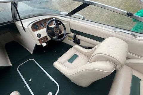 Slide: The Image of Interior of a 1995 Celebrity 180 Bowrider boat with beige seating and dashboard. - 9