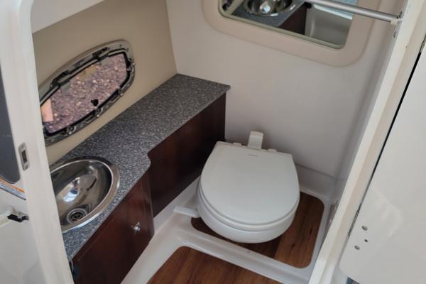 Slide: The Image of 2018 Chaparral 257 SSX boat bathroom with sink, toilet, and wooden flooring. - 12