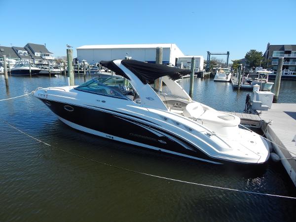 Slide: The Image of 2009 Chaparral 275 SSi boat docked in a marina, featuring sleek black and white design. - 0