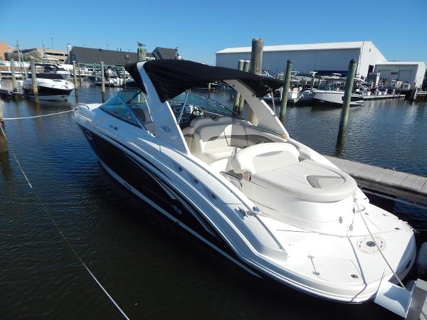 Slide: The Image of 2009 Chaparral 275 SSi boat docked in marina, featuring sleek design and black canopy. - 1
