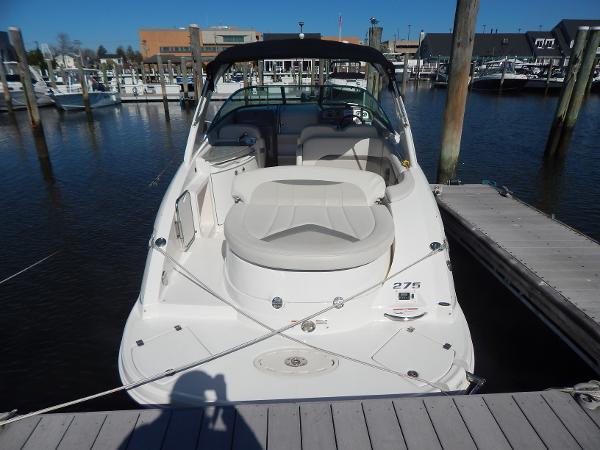 Slide: The Image of 2009 Chaparral 275 SSi boat docked at a marina, showcasing spacious seating and sleek design. - 2