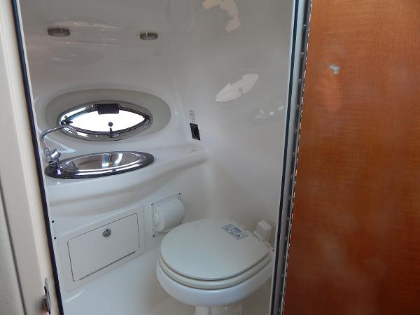 Slide: The Image of 2009 Chaparral 275 SSi boat bathroom with sink, toilet, and porthole window. - 23