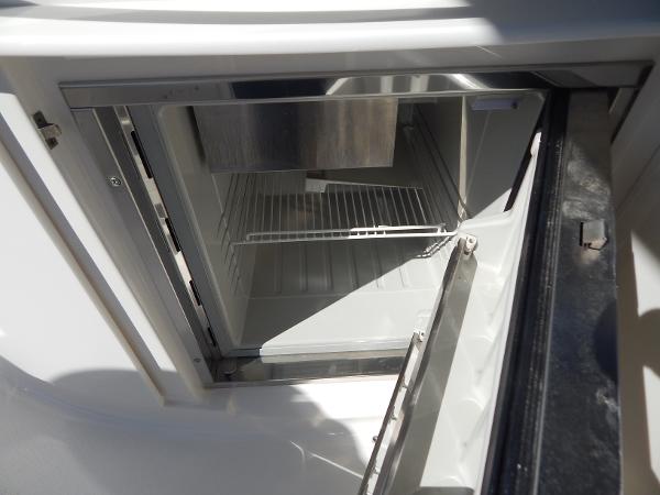 Slide: The Image of Open refrigerator on 2009 Chaparral 275 SSi boat, showcasing interior shelving. - 41