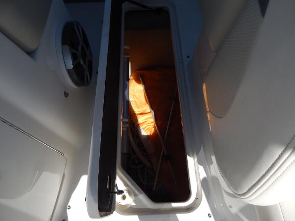 Slide: The Image of Storage compartment in 2009 Chaparral 275 SSi boat with visible speaker and orange life jacket. - 45