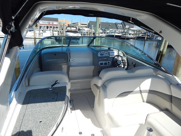Slide: The Image of 2009 Chaparral 275 SSi boat interior with helm, seating, and marina view. - 7